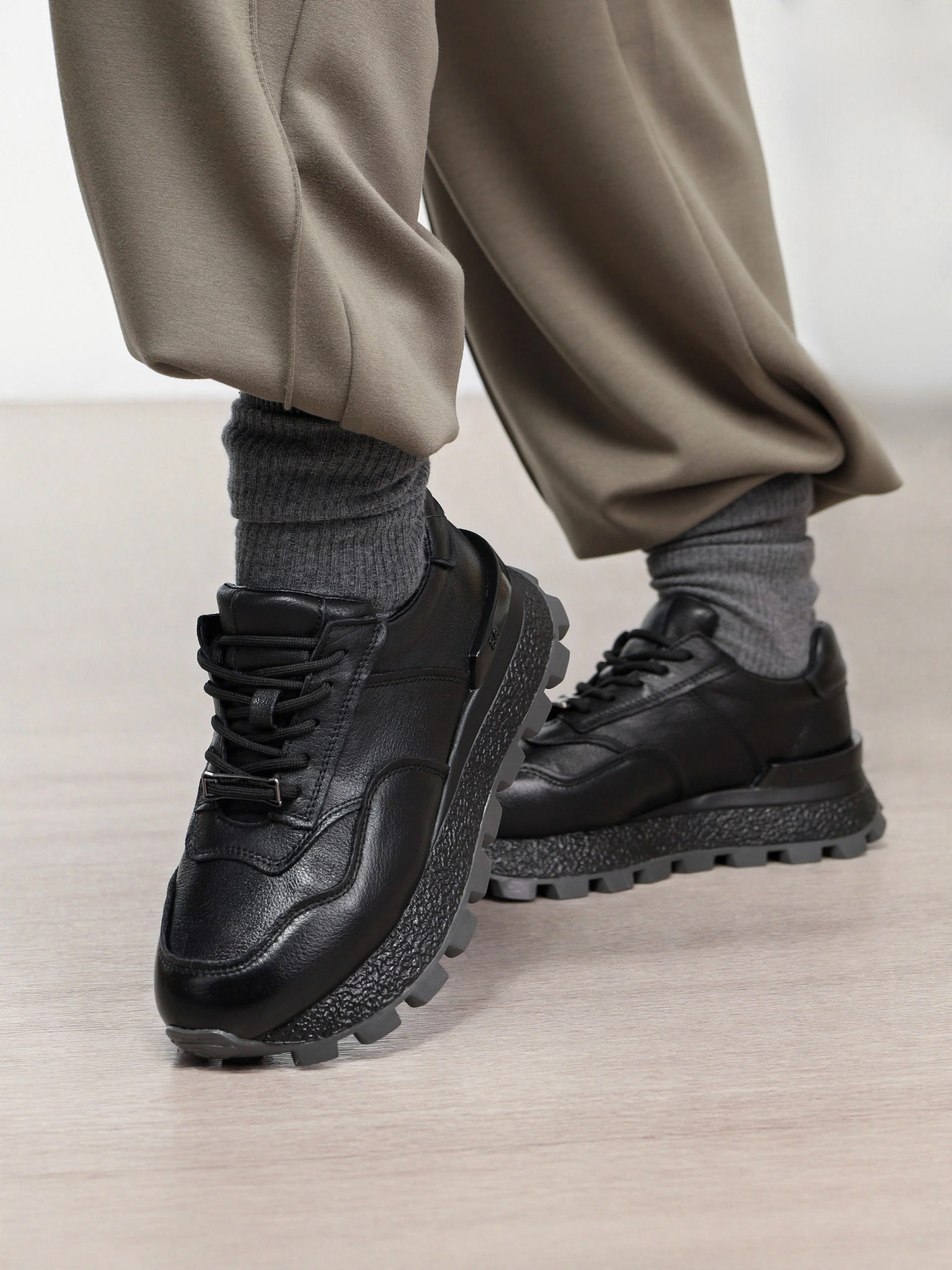 Кроссовки черного цвета с пряжкой на рельефной подошве 